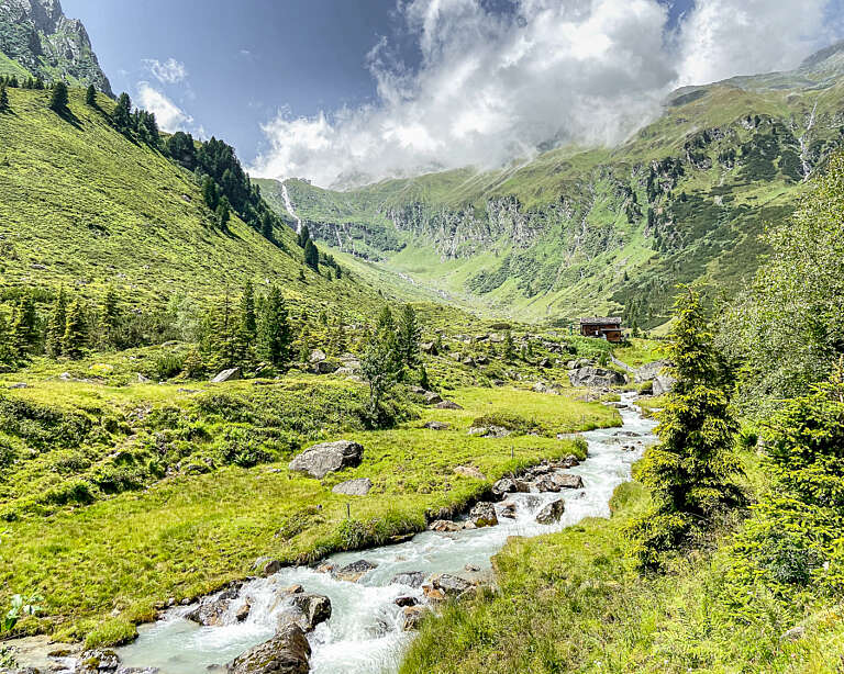 Der rauschende Falbesoner Bach mit Alm und der Regensburger Hütte im Hintergrund