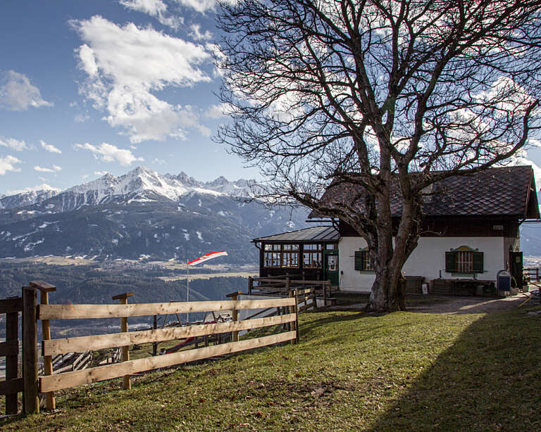Der Rauschbrunnen mit der verschneiten Nockspitze und den Kalkkögeln im Hintergrund